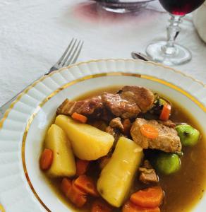 a plate of stew with meat and vegetables on a table at La Maison des Ifs Terracotta in Mamers