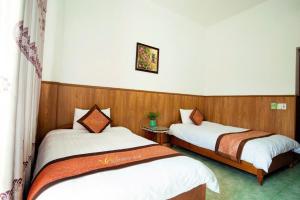 Dos camas en una habitación con paredes de madera. en Hương Sen Hotel MC - by BAY LUXURY, en Mộc Châu 3 fotos más