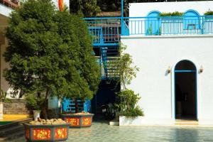 un edificio azul y blanco con un árbol en un patio en Hương Sen Hotel MC - by BAY LUXURY, en Mộc Châu