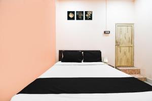 a bedroom with a large white bed in it at Super Hotel O Sofitel Hotel in Dhanbād