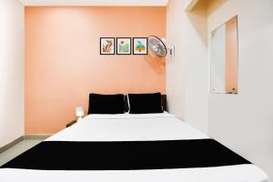 a bedroom with a white bed and a clock on the wall at Super Hotel O Sofitel Hotel in Dhanbād