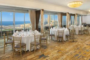 a dining room with tables and chairs and windows at Sheraton Jeddah Hotel in Jeddah