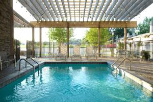una piscina con sillas y una pérgola en TownePlace Suites by Marriott Lafayette South, en Lafayette