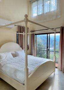 a bedroom with a white bed and a window at Flora Prairie at Mae Rim, Chiang Mai in Ban Tai