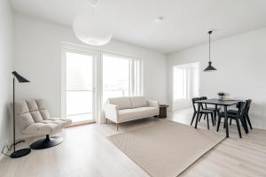 Una sala de estar blanca con una mesa y sillas. en Järvenpään Nuotti, en Järvenpää
