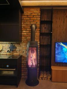 a wood stove in a room with a tv at Pamario rezidencija in Nida