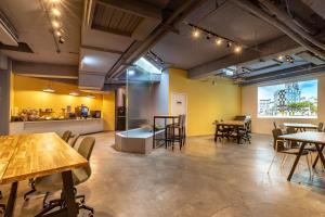 a room with tables and chairs and a kitchen at Hotel Papa Whale-Kaohsiung Formosa Boulevard in Kaohsiung