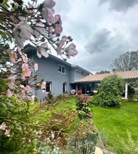 dom z różowymi kwiatami w ogrodzie w obiekcie Villa 8 personnes proche d'Hossegor au bord du Golf de Pinsolle w mieście Soustons +8 zdjęć