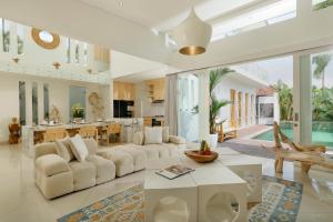 a living room with a white couch and a table at The Suar Sanur by Nakula in Sanur