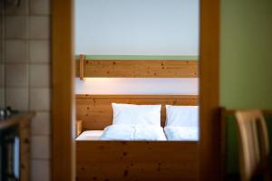 a bed with two pillows is shown through a door at Ferienpension Senfter in Innervillgraten