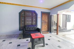 una stanza con una sedia e uno sgabello rosso di FabExpress Awadh Inn - 400m from Shri Ram Janam Bhumi a Ayodhya Altre 19 foto