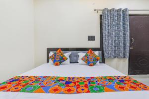 una camera da letto con un letto con un piumone colorato di FabExpress Awadh Inn - 400m from Shri Ram Janam Bhumi a Ayodhya