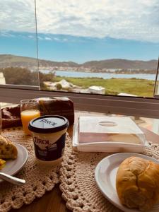 einen Tisch mit einem Teller Essen und einem Fenster in der Unterkunft Apartamento em Laguna SC in Laguna