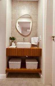 ein Badezimmer mit Waschbecken und Spiegel in der Unterkunft Apartamento em Laguna SC in Laguna