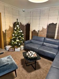 a living room with a blue couch and a christmas tree at Penzion Solid Spa in Mladá Boleslav