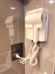 a phone is hanging on a wall in a bathroom at BB HOUSE Rangsit in Ban Talat Rangsit