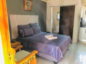 a bedroom with a bed with two towels on it at Hluzu Guest House in Hluhluwe +20 photos