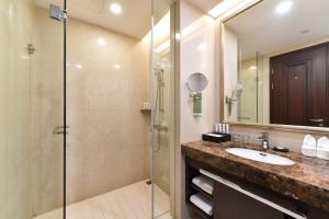 un bagno con lavandino e doccia di Evergreen Laurel Hotel, Shanghai a Shanghai