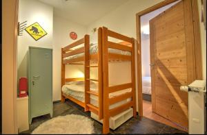 モントリオンにあるLe refuge de Montriondのベッドルーム1室(二段ベッド2台、ドア付)
