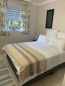 a bedroom with a large bed with a window at Cozy, 2 bedroom beachfront apartment in Ballito +5 photos