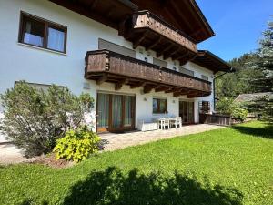 a house with a balcony and a yard at Sweet Alpen Home in Garmisch-Partenkirchen