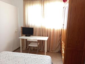 a bedroom with a desk with a computer on it at Habitación Hibisco en La Casa del Patio in Antequera