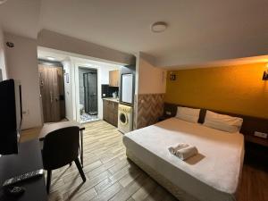 Un dormitorio con una cama, un escritorio y un televisor. en BetaS GuestHouse, en Antalya
