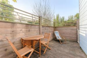 a patio with a table and chairs on a deck at Maison Athlos - Quartier calme au coeur de Nantes in Nantes