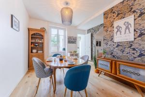 a dining room with a wooden table and blue chairs at Maison Athlos - Quartier calme au coeur de Nantes in Nantes +7 photos