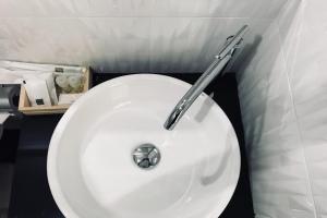 a bathroom with a white sink with a metal handle at Snooze Inn Phuket - Free Shuttle to Bang Rong Pier in Ban Pa Khlok +20 photos