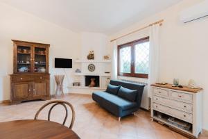 a living room with a blue couch and a tv at Le Tuie in Castellammare del Golfo +15 photos