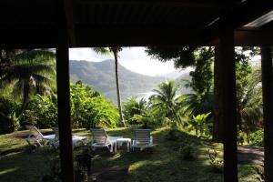 a porch with chairs and a view of a mountain at HUAHINE Manta Lodge avec 4x4 optionnel in Haapu +24 photos
