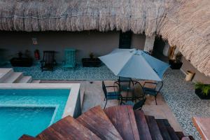 een parasol en stoelen naast een zwembad bij Cielito 1 in Tulum