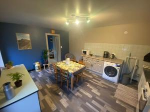 eine Küche mit einem Tisch und einer Waschmaschine in der Unterkunft Le Gîte du Chat Gru in Saulxures-sur-Moselotte