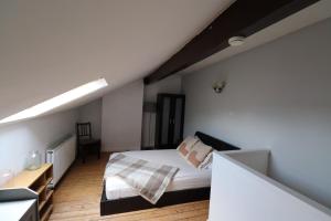 a attic bedroom with a bed and a desk at Dweller Holiday Homes in Headingley