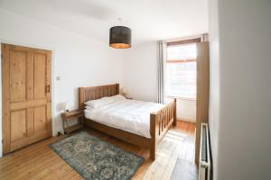 a bedroom with a bed and a window at Dweller Holiday Homes in Headingley