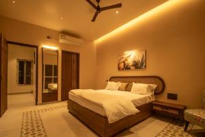 NandiRASA Pool Villa的一间带大床和吊扇的卧室