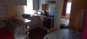 - une petite cuisine avec une table et un comptoir dans l'établissement MH372 camping Bois Dormant 6pers, à Saint-Jean-de-Monts