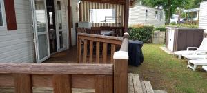 une clôture en bois sur une terrasse couverte d'une maison dans l'établissement MH372 camping Bois Dormant 6pers, à Saint-Jean-de-Monts