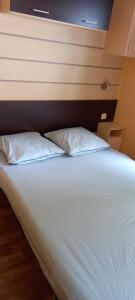 un lit avec deux oreillers dessus dans une chambre dans l'établissement MH372 camping Bois Dormant 6pers, à Saint-Jean-de-Monts