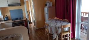 une cuisine avec une table avec des chaises et un réfrigérateur dans l'établissement MH372 camping Bois Dormant 6pers, à Saint-Jean-de-Monts 5 autres photos