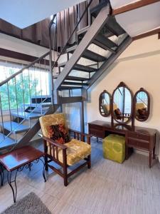 Habitación con silla y escalera con espejos en Finikous Cottage House-Agros, en Agros