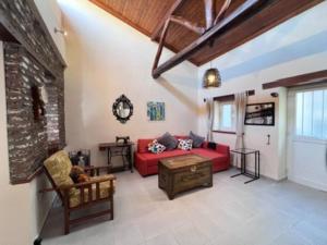 Una sala de estar con un sofá rojo y una chimenea. en Finikous Cottage House-Agros, en Agros