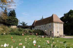 a building with a field of flowers in front of it at LA MOTTE FÉODALE luxury medieval MANOR rated 5 stars in Normandy in Le Mesnil-Jourdain