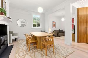 a kitchen and living room with a wooden table and chairs at 2-4 Trinity Avenue in Sydney