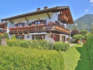 a house with a balcony with flowers on it at Ferienwohnungen Isarwinkel in Krün