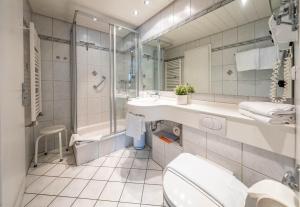 a bathroom with a toilet and a sink and a tub at Ferienwohnungen Isarwinkel in Krün +37 photos
