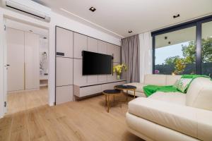 a living room with a white couch and a tv at Villa Vista Maris in Crikvenica