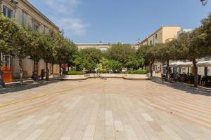 an empty street in a city with trees and buildings at Ricasoli27 in Mottola +11 photos