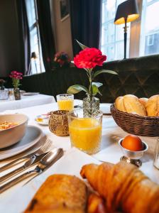 een tafel met een bord brood en sinaasappelsap bij The Velvet Lodge in Den Haag